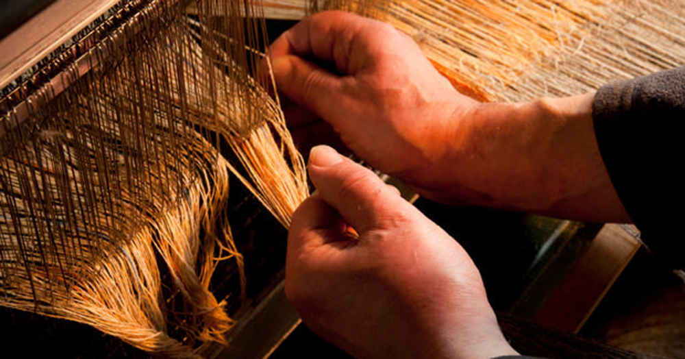 The Harris Tweed® weaver ties in the yarns by hand.